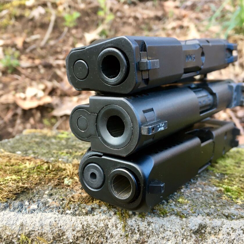 9mm 1911 flanked by M&P Shield and Glock 19